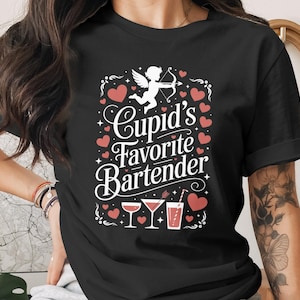 May include: Black t-shirt with a white graphic that reads "Cupid's Favorite Bartender." The design includes a cupid with a bow and arrow, red hearts, and illustrations of cocktails. A fun Valentine's Day or romantic gift.