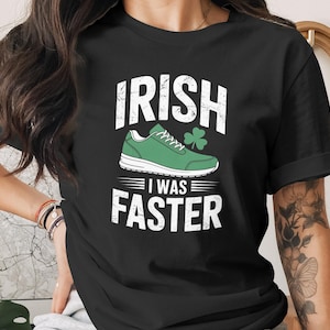 May include: Black t-shirt with the text "IRISH I WAS FASTER" in white, featuring a green running shoe and a shamrock. The design has a distressed, vintage look, perfect for St. Patrick's Day.
