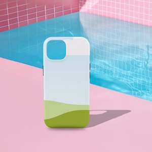 May include: A white and green phone case with a landscape design. The case features a gradient of light blue to white, with a green, rolling hill design at the bottom. The case has black buttons on the side and a camera cutout.