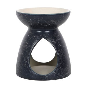 May include: A dark blue ceramic oil burner with a white glaze and a teardrop-shaped opening. The burner has a distressed finish.