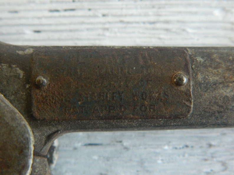 K&ouml;nnte beinhalten: Nahaufnahme eines Metallwerkzeugs mit einem Etikett mit der Aufschrift "The L.S. Starrett Co. Athol Mass. U.S.A. Pat'd 608".