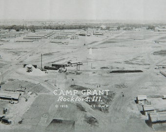 Könnte beinhalten: Eine Luftaufnahme von Camp Grant in Rockford, Illinois, die eine große Militärbasis mit Baracken und anderen Gebäuden zeigt. Das Foto wurde 1918 aufgenommen und enthält den Text "Camp Grant Rockford, Ill. © 1918. C.E.-Dor.P."