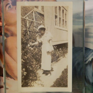 Vintage photo woman stops and smells the roses 1930s fashion hat purse church original found old vernacular photograph photography snapshot