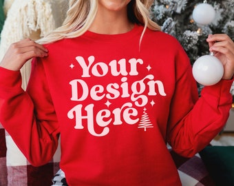 May include: Red sweatshirt with the text "Your Design Here" in pink lettering with a small Christmas tree graphic.