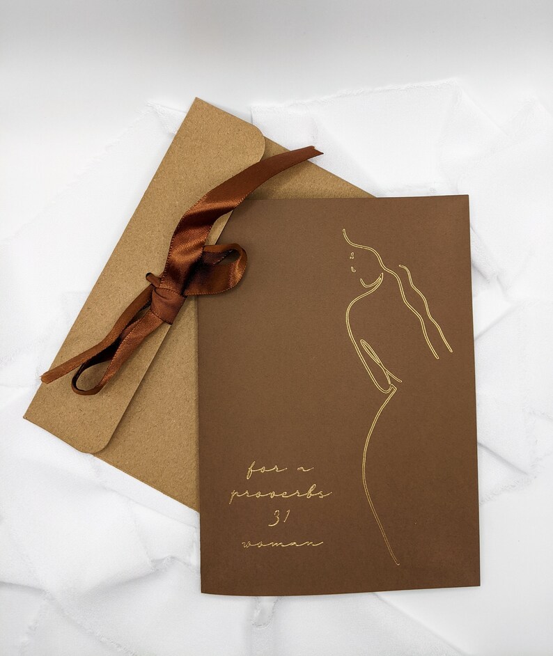 May include: A brown card with a gold outline of a woman and the text "for a proverbs 31 woman" in gold lettering.