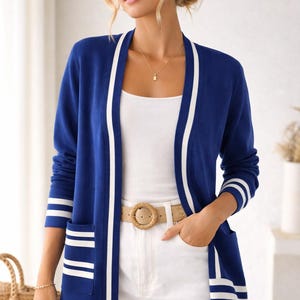 May include: A white ceramic mug with a black handle and the text "But First, Coffee" in a black, bold font. The mug is on a white surface. The mug is likely for hot beverages.