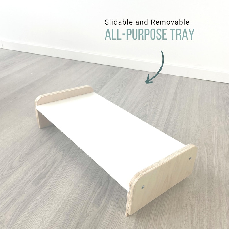 May include: A white, rectangular tray with wooden edges. The tray is slidable and removable. The text "ALL-PURPOSE TRAY" is written in green on a white background.