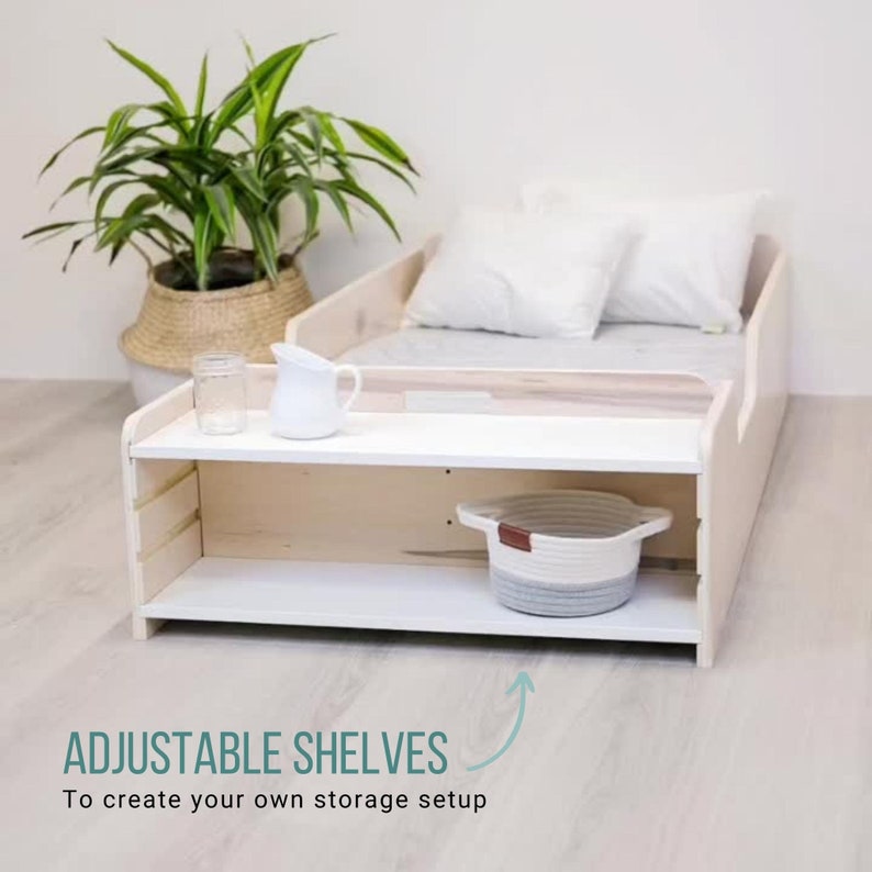 May include: A white wooden bed frame with adjustable shelves. The shelves are made of white wood and have a white finish. The bed frame is made of natural wood and has a light wood finish. The bed frame has a white mattress and two white pillows. The bed frame is sitting on a light wood floor. The text "ADJUSTABLE SHELVES" is written in green on a white background. The text "To create your own storage setup" is written in black on a white background.