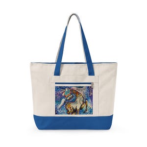 May include: Cream-colored tote bag with a blue base, trim, and handles. The front features a colorful illustration of a unicorn. The unicorn has a white body, a flowing mane, and is decorated with vibrant patterns and colors.