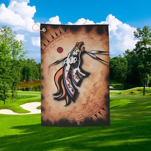 May include: A white ceramic mug with a black handle and the text "But First, Coffee" in a bold, black font. The mug is set against a blurred background, suggesting a cozy setting.