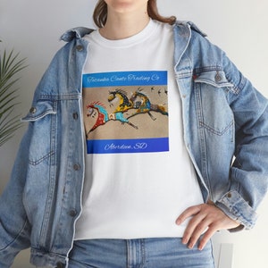 May include: White t-shirt with a colorful image of three horses running. The image is surrounded by a blue border with the text "Tatanka Canta Trading Co. Aberdeen, SD".