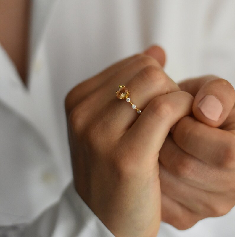 Handmade and dainty jewelry made in Montreal by Piper & Pearl Jewelry. Feminine, modern and delicate, perfect for a gift for her. Collections of costume, vermeil and fine jewelry. Rose pink oval cut pave promise ring on a gold band.