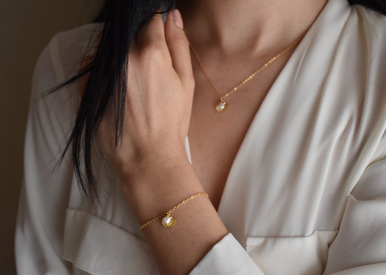 Handmade and dainty jewelry made in Montreal by Piper & Pearl Jewelry. Feminine, modern and delicate, perfect for a gift for her. Collections of costume, vermeil and fine jewelry. Seashell and pearl gold charm bracelet with beachy and boho vibes.