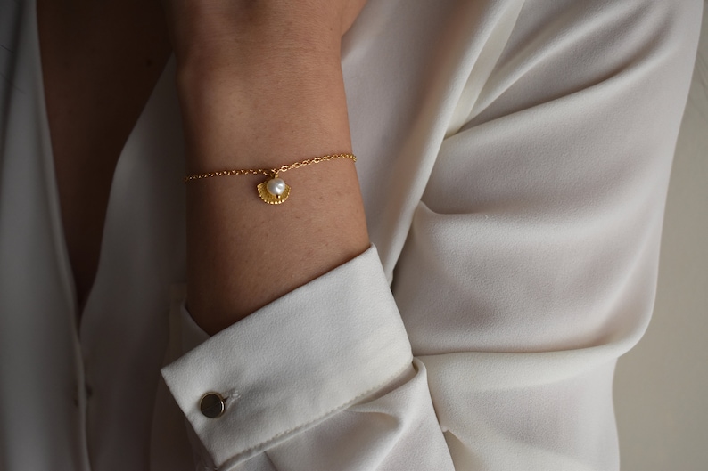Handmade and dainty jewelry made in Montreal by Piper & Pearl Jewelry. Feminine, modern and delicate, perfect for a gift for her. Collections of costume, vermeil and fine jewelry. Seashell and pearl gold charm bracelet with beachy and boho vibes.