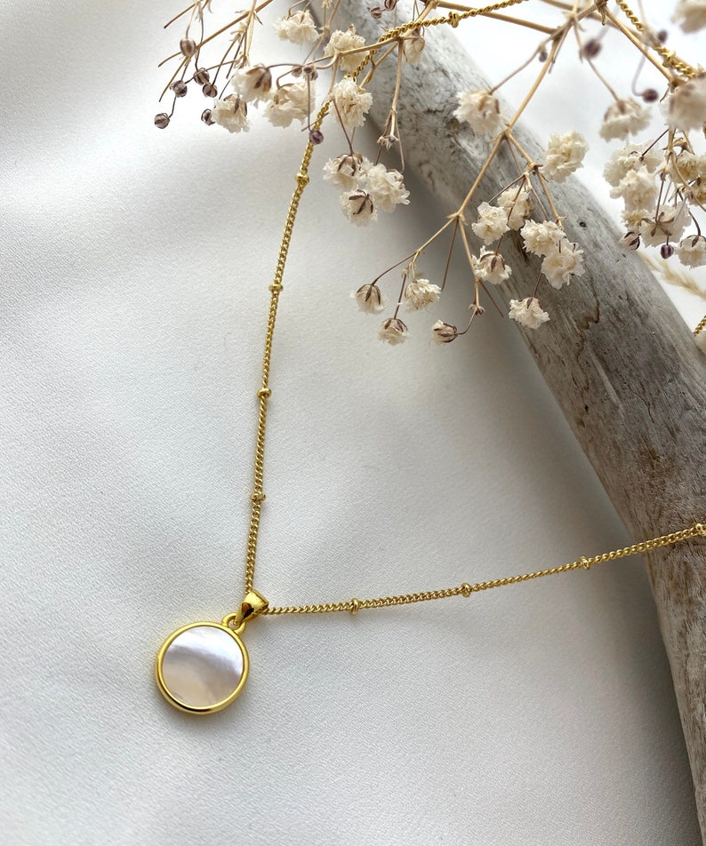 Handmade and dainty jewelry made in Montreal by Piper & Pearl Jewelry. Feminine, modern and delicate, perfect for a gift for her. Collections of costume, vermeil and fine jewelry. A mother of pearl medallion coin necklace on a satellite chain.