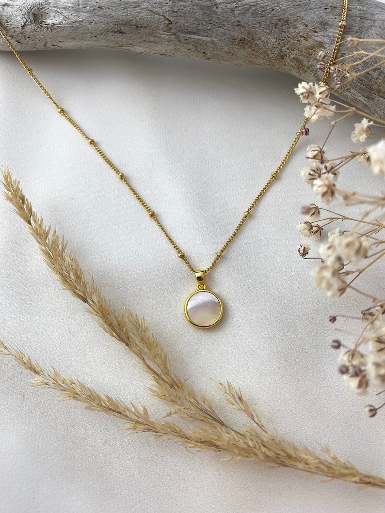 Handmade and dainty jewelry made in Montreal by Piper & Pearl Jewelry. Feminine, modern and delicate, perfect for a gift for her. Collections of costume, vermeil and fine jewelry. A mother of pearl medallion coin necklace on a satellite chain.