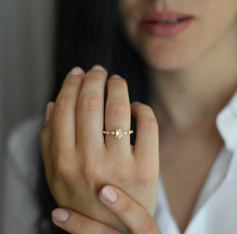 Handmade and dainty jewelry made in Montreal by Piper & Pearl Jewelry. Feminine, modern and delicate, perfect for a gift for her. Collections of costume, vermeil and fine jewelry. Rose pink oval cut pave promise ring on a gold band.