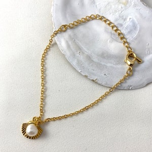 Handmade and dainty jewelry made in Montreal by Piper & Pearl Jewelry. Feminine, modern and delicate, perfect for a gift for her. Collections of costume, vermeil and fine jewelry. Seashell and pearl gold charm bracelet with beachy and boho vibes.