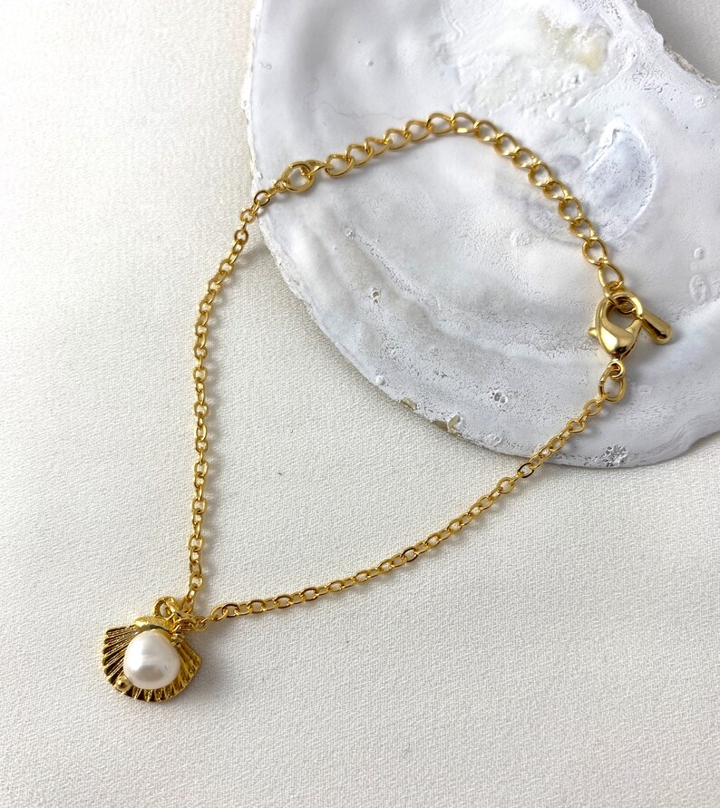 Handmade and dainty jewelry made in Montreal by Piper & Pearl Jewelry. Feminine, modern and delicate, perfect for a gift for her. Collections of costume, vermeil and fine jewelry. Seashell and pearl gold charm bracelet with beachy and boho vibes.