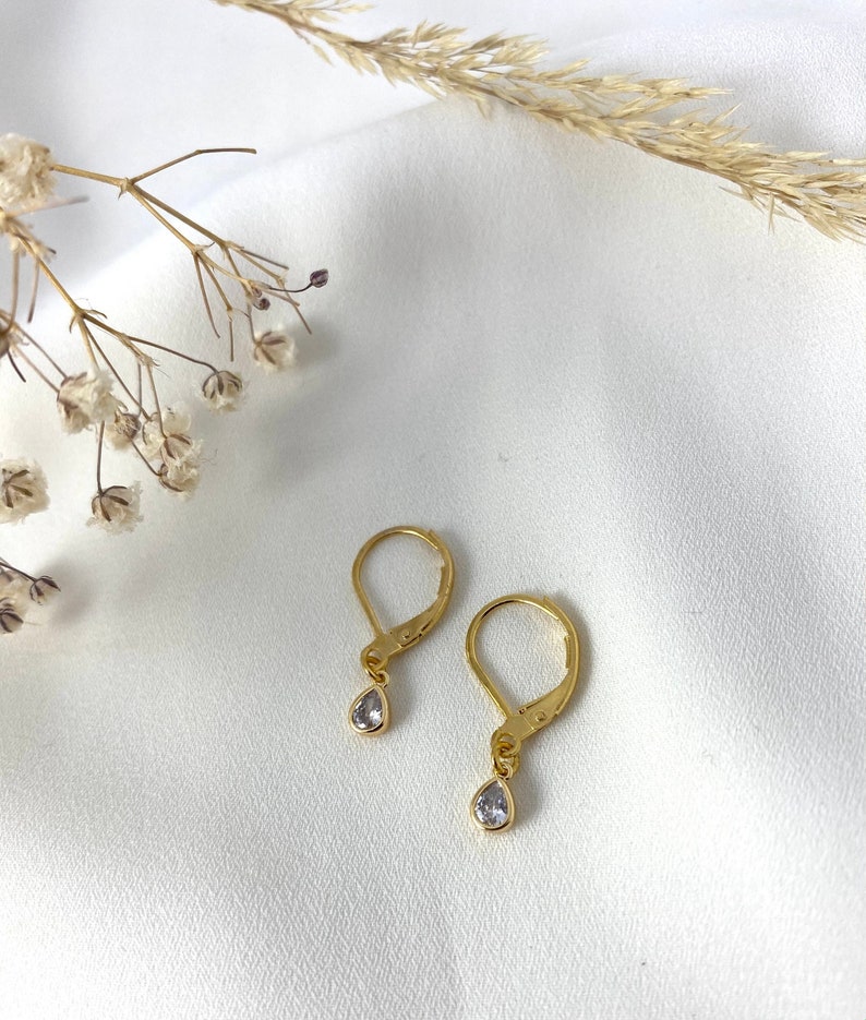 Handmade and dainty jewelry made in Montreal by Piper & Pearl Jewelry. Feminine, modern and delicate, perfect for a gift for her. Collections of costume, vermeil and fine jewelry. Dainty gold dangle drop earrings with delicate zirconia.