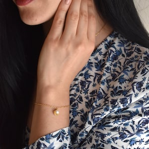Handmade and dainty jewelry made in Montreal by Piper & Pearl Jewelry. Feminine, modern and delicate, perfect for a gift for her. Collections of costume, vermeil and fine jewelry. Seashell and pearl gold charm bracelet with beachy and boho vibes.