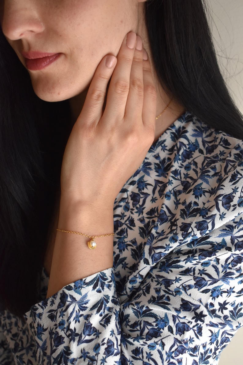 Handmade and dainty jewelry made in Montreal by Piper & Pearl Jewelry. Feminine, modern and delicate, perfect for a gift for her. Collections of costume, vermeil and fine jewelry. Seashell and pearl gold charm bracelet with beachy and boho vibes.