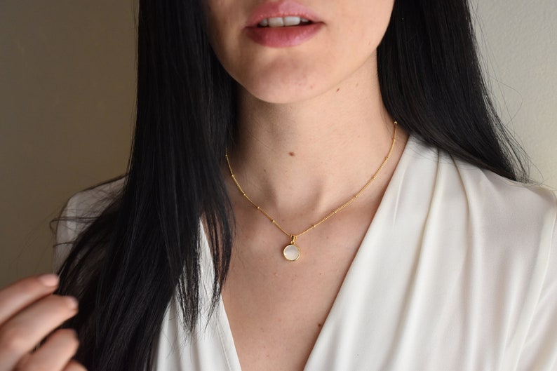 Handmade and dainty jewelry made in Montreal by Piper & Pearl Jewelry. Feminine, modern and delicate, perfect for a gift for her. Collections of costume, vermeil and fine jewelry. A mother of pearl medallion coin necklace on a satellite chain.