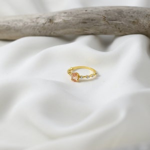 Handmade and dainty jewelry made in Montreal by Piper & Pearl Jewelry. Feminine, modern and delicate, perfect for a gift for her. Collections of costume, vermeil and fine jewelry. Rose pink oval cut pave promise ring on a gold band.