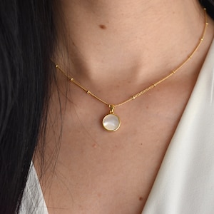 Handmade and dainty jewelry made in Montreal by Piper & Pearl Jewelry. Feminine, modern and delicate, perfect for a gift for her. Collections of costume, vermeil and fine jewelry. A mother of pearl medallion coin necklace on a satellite chain.