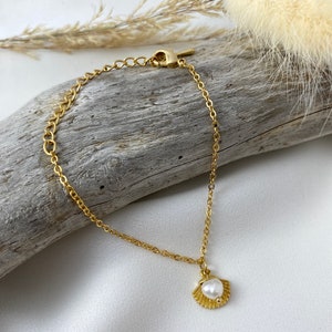 Handmade and dainty jewelry made in Montreal by Piper & Pearl Jewelry. Feminine, modern and delicate, perfect for a gift for her. Collections of costume, vermeil and fine jewelry. Seashell and pearl gold charm bracelet with beachy and boho vibes.