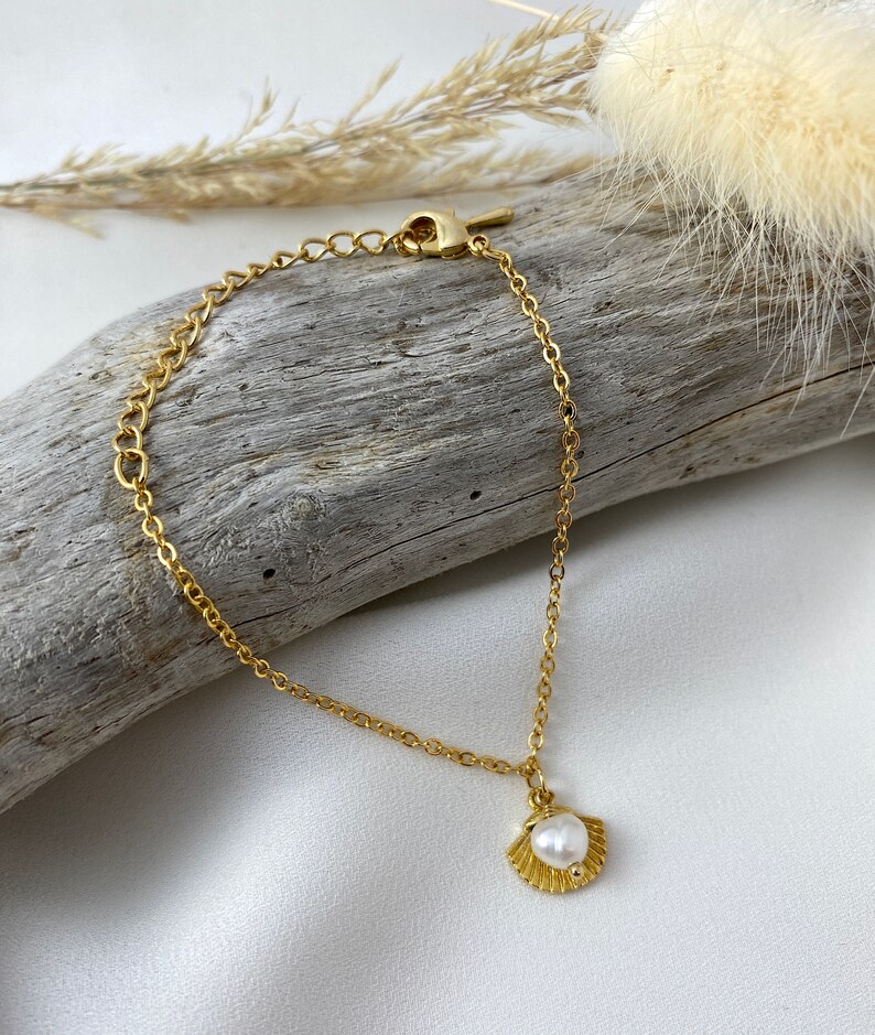 Handmade and dainty jewelry made in Montreal by Piper & Pearl Jewelry. Feminine, modern and delicate, perfect for a gift for her. Collections of costume, vermeil and fine jewelry. Seashell and pearl gold charm bracelet with beachy and boho vibes.