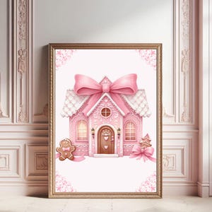 May include: A pink gingerbread house with white frosting and a large pink bow on top. There are two gingerbread people on either side of the house.