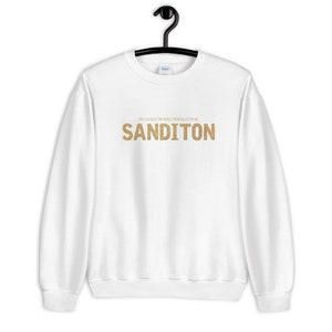 Puede incluir: Sudadera blanca con texto en purpurina dorada que dice "Físicamente estoy aquí, mentalmente estoy en Sanditon."