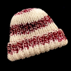 May include: White and burgundy striped knit beanie hat.