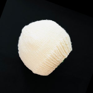 May include: A white knitted beanie hat with a soft, fluffy texture.