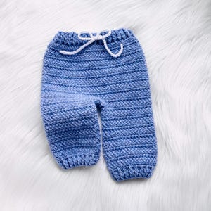 May include: Blue crocheted baby pants with a white drawstring.