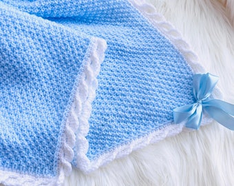 May include: A light blue crocheted baby blanket with a white crocheted border and a light blue satin bow.