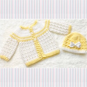 Puede incluir: Un c&aacute;rdigan de beb&eacute; blanco tejido a crochet con ribetes amarillos y un gorro a juego tejido a crochet amarillo con un lazo blanco.
