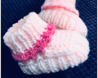 May include: A pair of pink knitted baby booties with a pink crocheted trim around the top of each bootie.