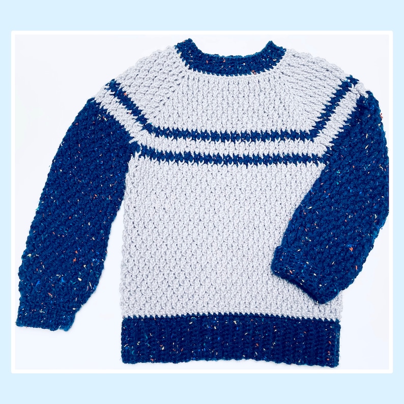 May include: A gray and blue crocheted sweater with a striped pattern. The sweater has long sleeves and a round neckline.