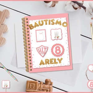 Puede incluir: Cuaderno de espiral rosa con letras doradas con purpurina que dicen "Bautismo Arely" y lunares dorados con purpurina. El cuaderno tiene varias pegatinas en la parte delantera, incluyendo un vestido blanco, velas, un escudo con las letras "HLT" y un círculo rosa con el número "8".