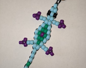 Lagarto con cuentas azules, verdes y púrpuras