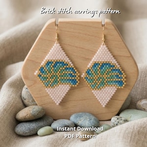 Peut inclure: Une paire de boucles d'oreilles en point de brique en forme de losange avec un fond rose clair et un motif de feuilles bleu et vert. Le texte "Brick stitch earrings pattern" et "Instant Download PDF Pattern" est visible sur l'image.