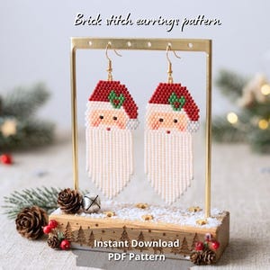 May include: A pair of beaded brick stitch earrings shaped like Santa Claus faces with red hats, white beards, and green holly accents, hanging from a gold metal display stand. The text "Brick stitch earrings pattern" and "Instant Download PDF Pattern" is visible.