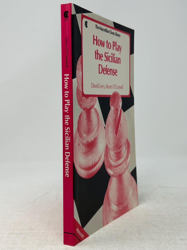 K&ouml;nnte beinhalten: Ein Buch mit dem Titel "How to Play the Sicilian Defense" von David Levy und Kevin O'Connell. Das Buch hat einen pinkfarbenen Buchr&uuml;cken mit dem Titel und dem Namen des Autors. Das Cover zeigt Schachfiguren in Rosa und Wei&szlig;, mit dem Titel in Rot.