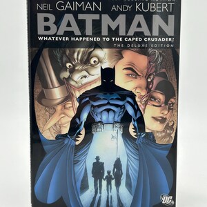 May include: A hardcover Batman comic book, "Whatever Happened to the Caped Crusader?" by Neil Gaiman and Andy Kubert. The cover features Batman in a blue and black suit, with other characters and the DC Comics logo.