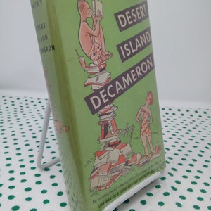Może przedstawiać: Zielona okładka książki z tytułem "Desert Island Decameron" autorstwa H. Allena Smitha. Okładka przedstawia rysunkową ilustrację mężczyzny czytającego książkę, siedzącego na stosie książek. Na dole okładki znajduje się tekst "An unconventional anthology of American humor".