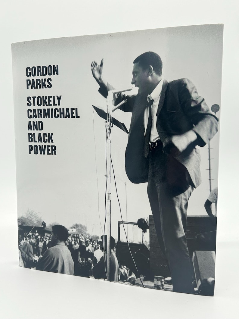May include: Black and white photograph of a book cover featuring a man speaking into a microphone. The book title reads "GORDON PARKS STOKELY CARMICHAEL AND BLACK POWER". The image shows a crowd of people in the background.
