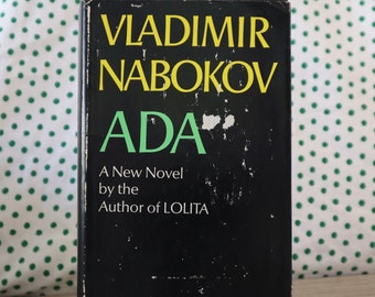 Könnte beinhalten: Ein schwarzes Buch mit dem Titel "ADA" von Vladimir Nabokov. Das Buch ist ein neuer Roman des Autors von Lolita.