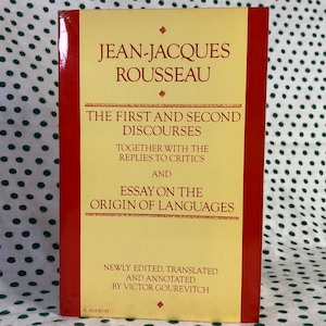 May include: A yellow and red book titled "Jean-Jacques Rousseau: The First and Second Discourses, Together with the Replies to Critics and Essay on the Origin of Languages." The book is newly edited, translated, and annotated by Victor Gourevitch.